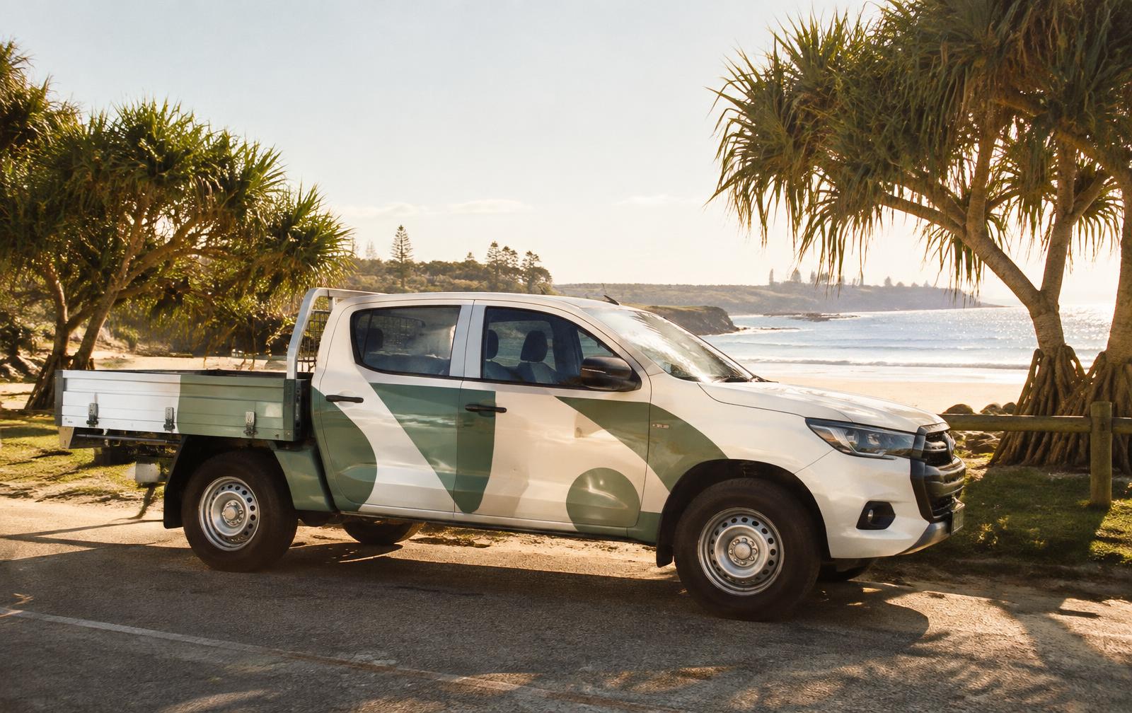 A freshly wrapped work ute near the beach